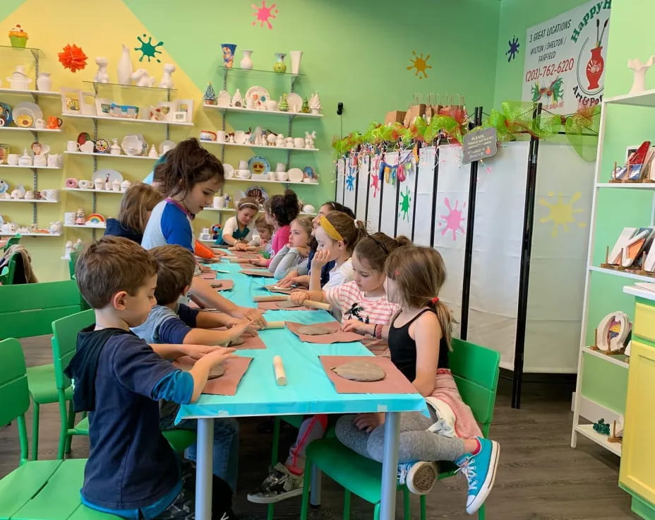 a group of children sitting at a table in a classroom