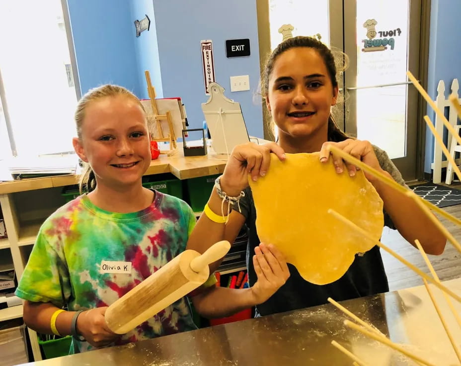 a couple of girls holding a yellow bucket