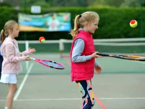 girls playing tennis on court