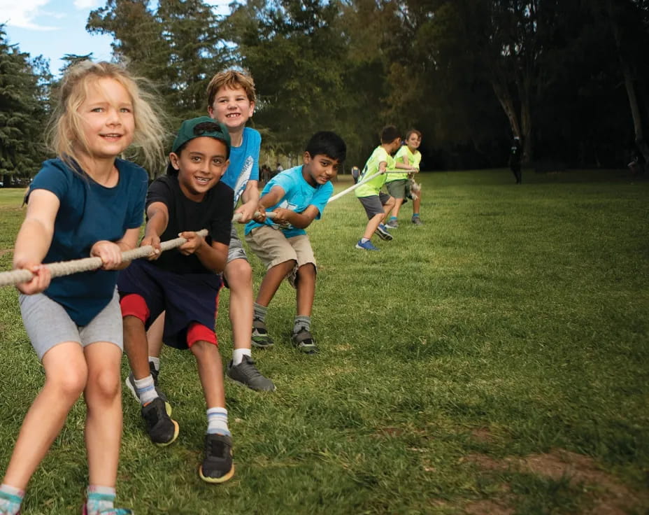 a group of kids running on a grassy field