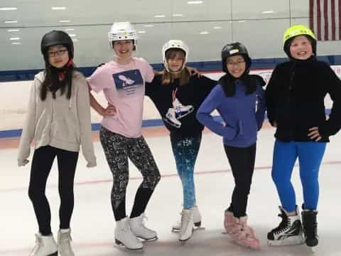 a group of women wearing helmets and ice skates