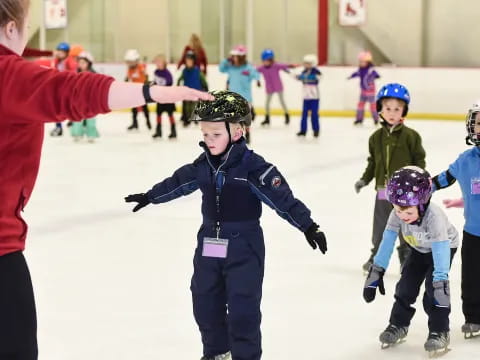 a person and kids on an ice rink