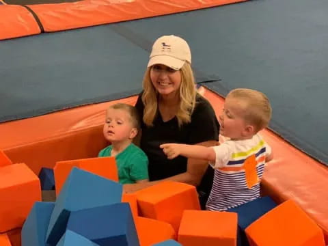 a person and two children playing on a toy train