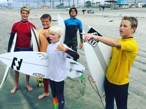 a group of kids holding surfboards