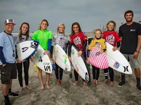 a group of people holding surfboards