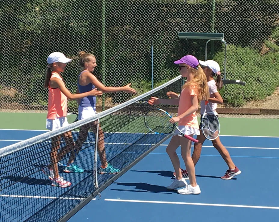 a group of girls playing tennis