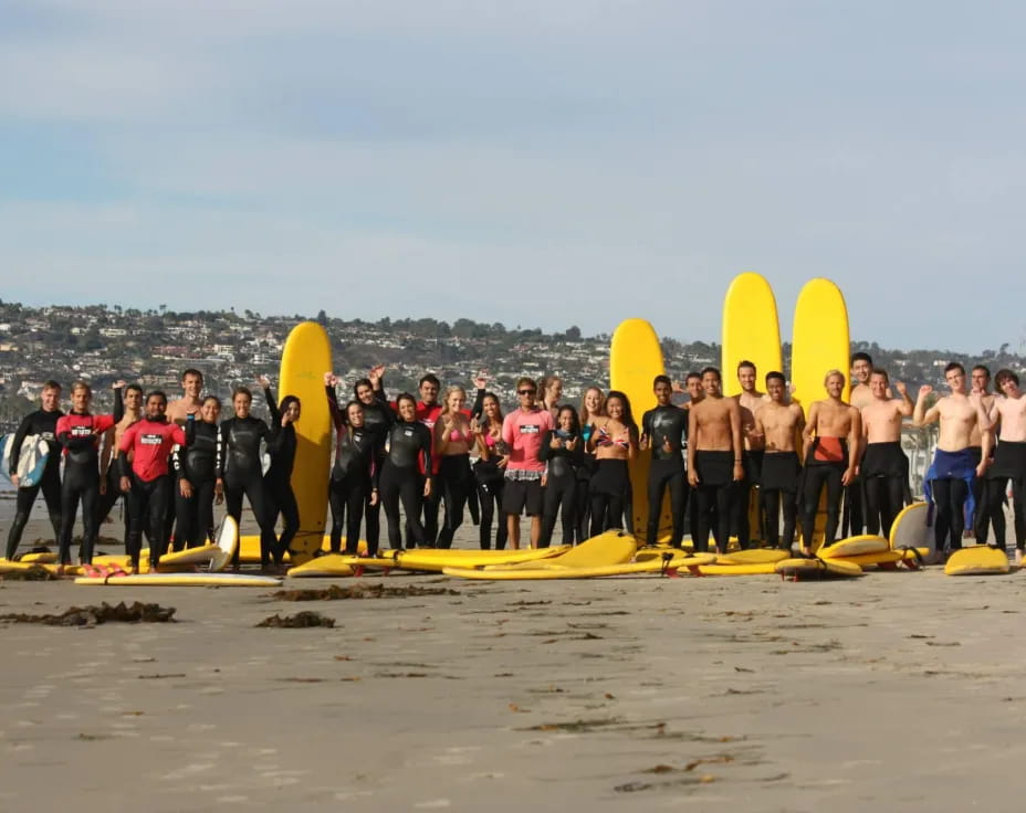 a group of surfers pose for a photo