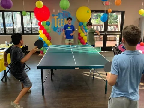 a group of people playing ping pong