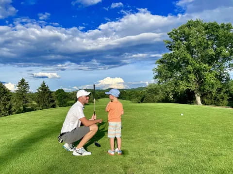 a person and a boy playing golf