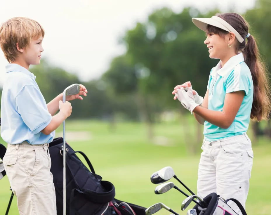 a person and a boy on a golf course
