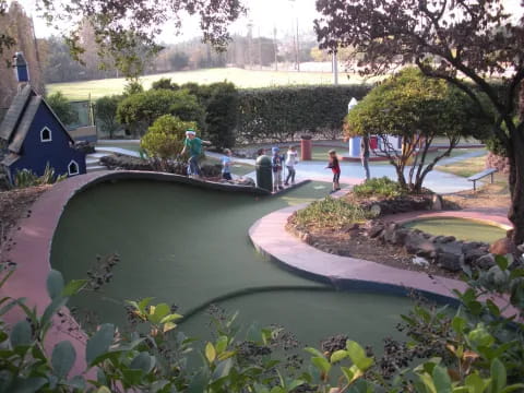 a group of people standing around a pond