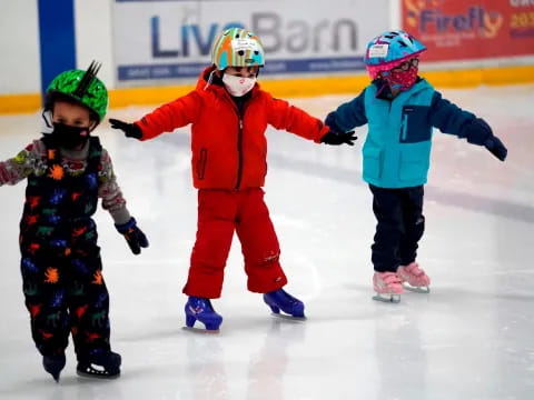 a group of kids wearing ice skates and helmets
