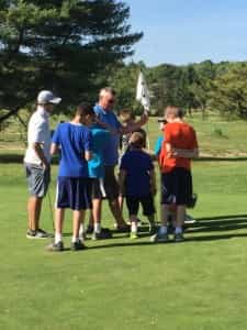 a group of people standing on a golf course