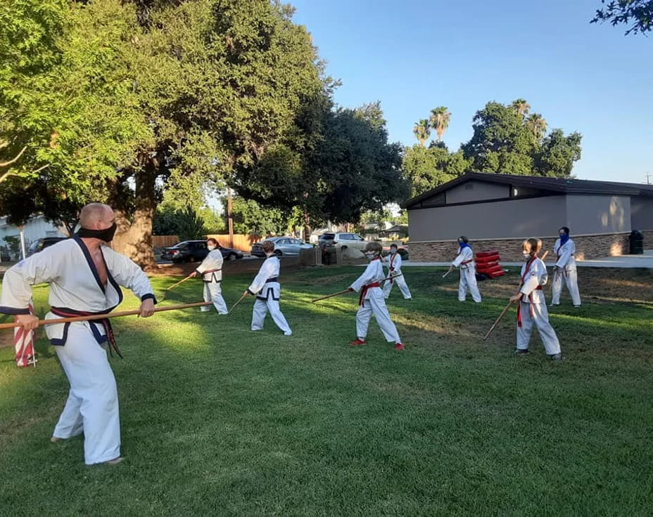 a group of people in white uniforms practicing martial arts