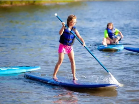 a couple of kids on paddle boards