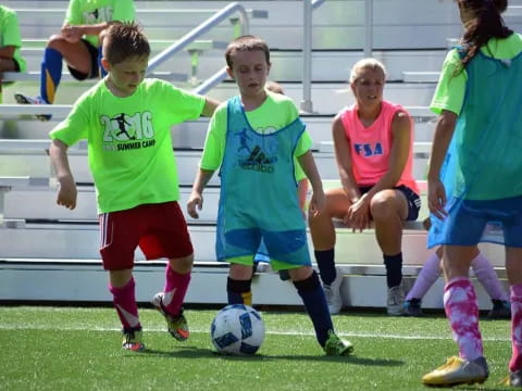 a group of kids compete over a football ball