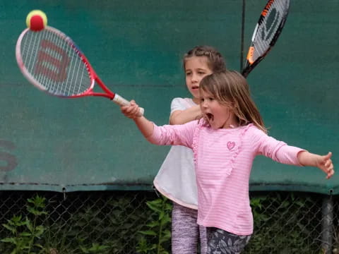 a couple of girls playing tennis