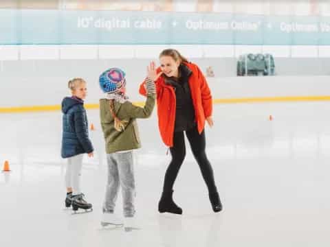 a person and two children on an ice rink