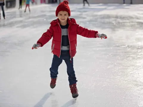 a child wearing a red hat and ice skates