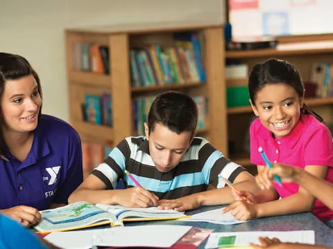 a group of children sitting at a table in a library