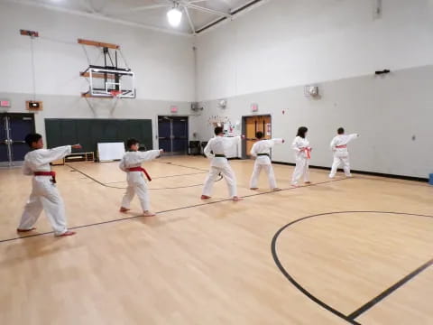 a group of people in white karate uniforms in a room