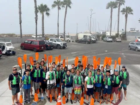 a group of people standing in a parking lot with orange cones