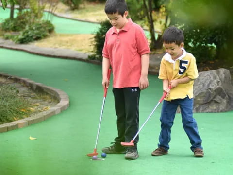 two boys holding golf clubs