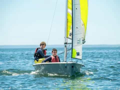 a couple of people on a sailboat in the water