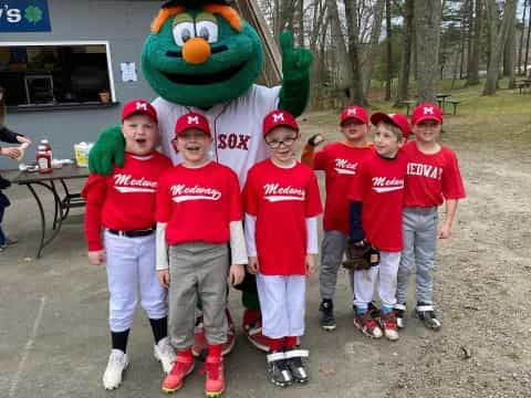 a group of kids wearing red shirts and hats