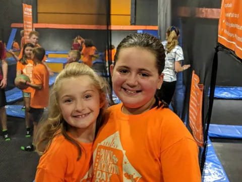 a couple of girls in orange shirts