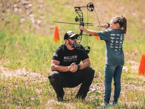 a man shooting a bow and arrow at a woman