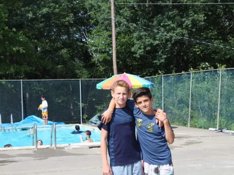 a couple of boys posing for a picture with an umbrella