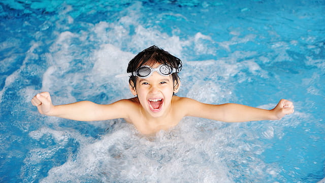 a boy swimming in a pool