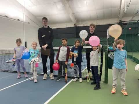 a group of kids holding tennis rackets