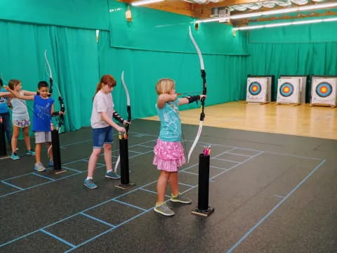 a group of kids playing archery