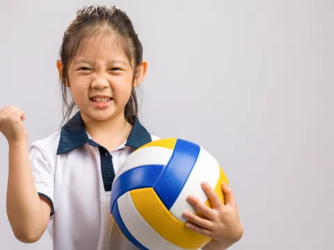 a little girl holding a ball