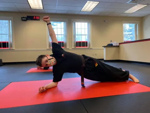 a person doing a plank on a mat in a room with windows