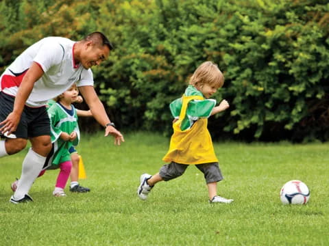 a person and a group of kids playing football