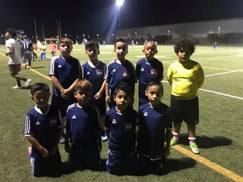 a group of boys posing for a picture on a football field