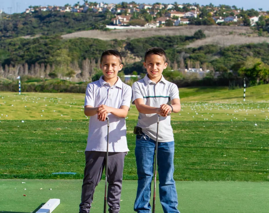 two boys standing on a golf course