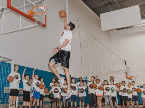 a man jumping to dunk a basketball