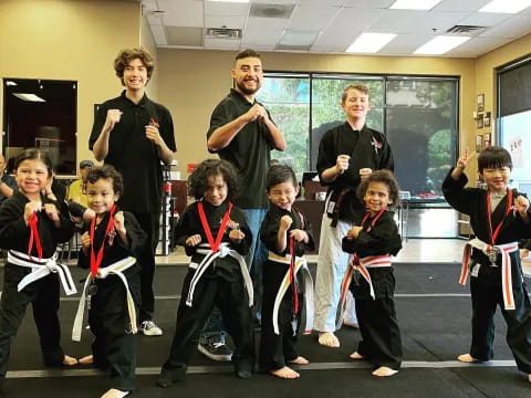 a group of children in black and red karate uniforms