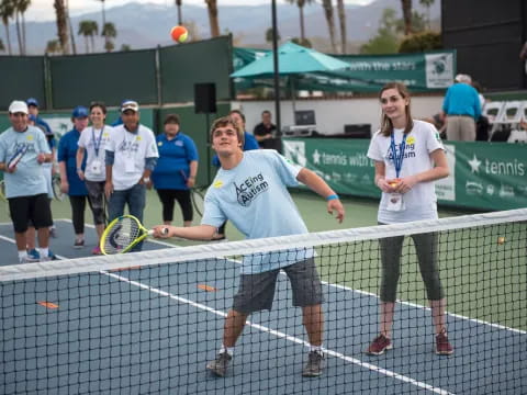 a couple of people holding tennis rackets on a tennis court
