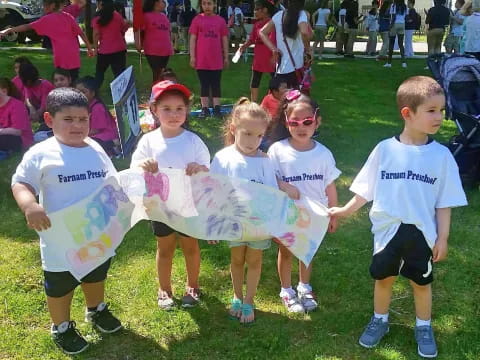 a group of children in matching white t-shirts and matching outfits