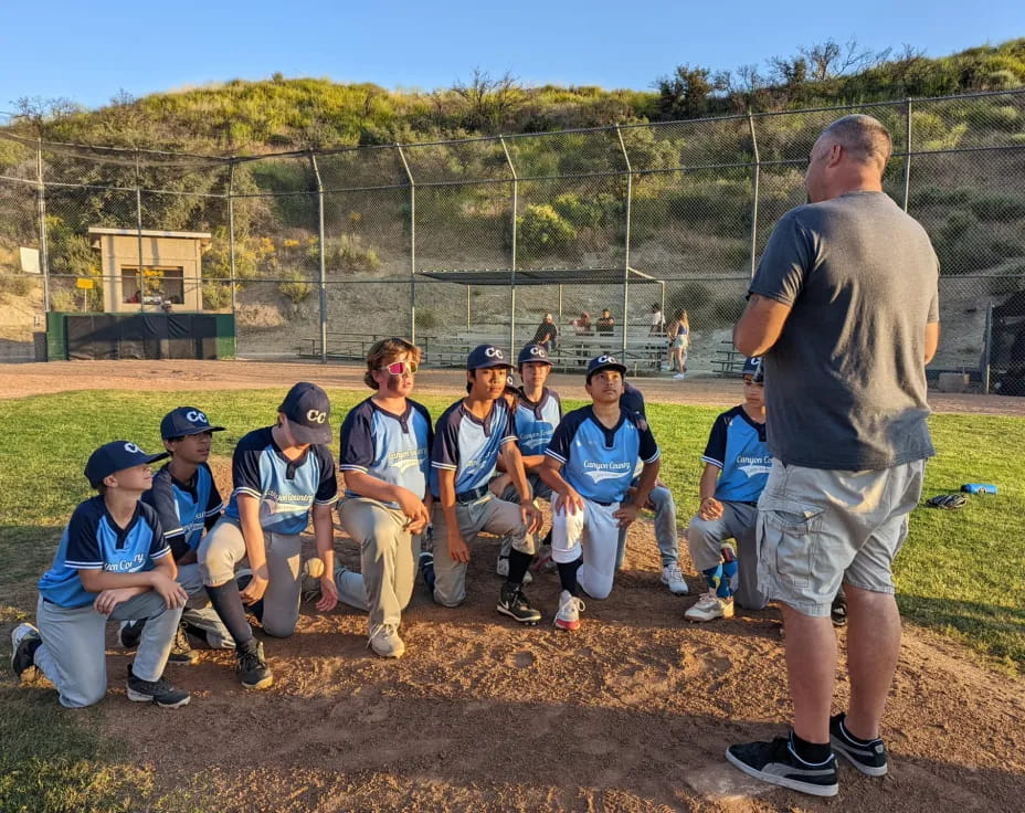 a baseball player talking to a group of kids