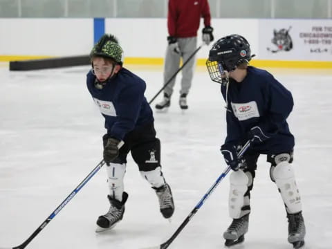 two people wearing hockey uniforms and holding sticks