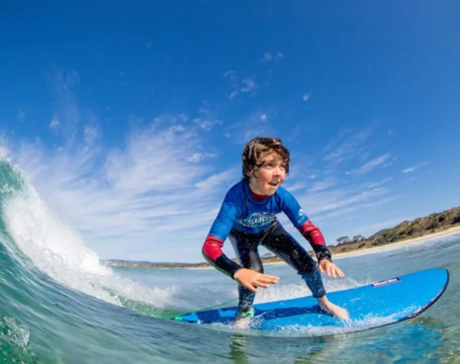 a boy riding a surfboard