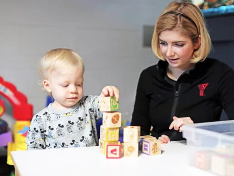 a person and a child playing with blocks