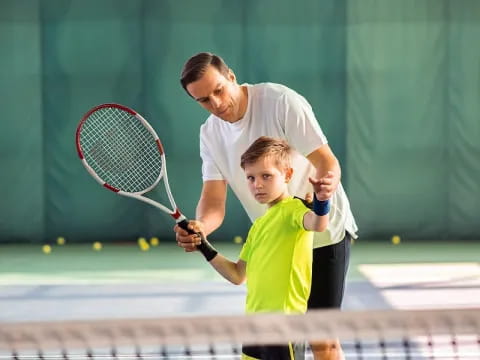 a man and a boy playing tennis