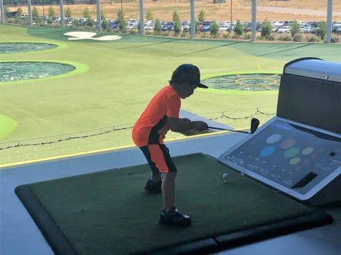a boy playing miniature golf